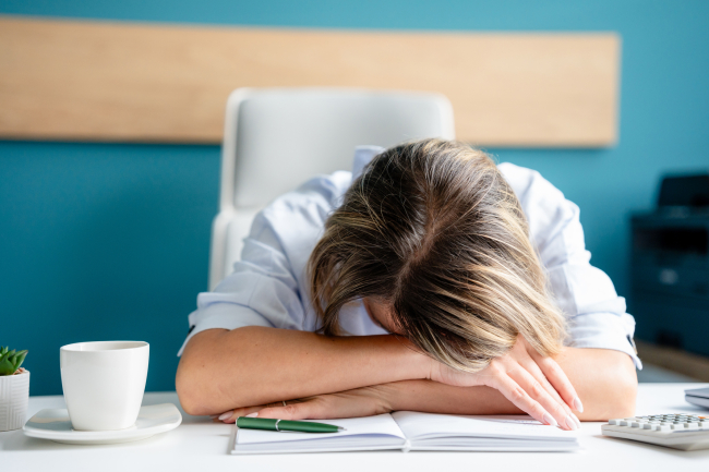 Overworked office worker laying her head down on the desk