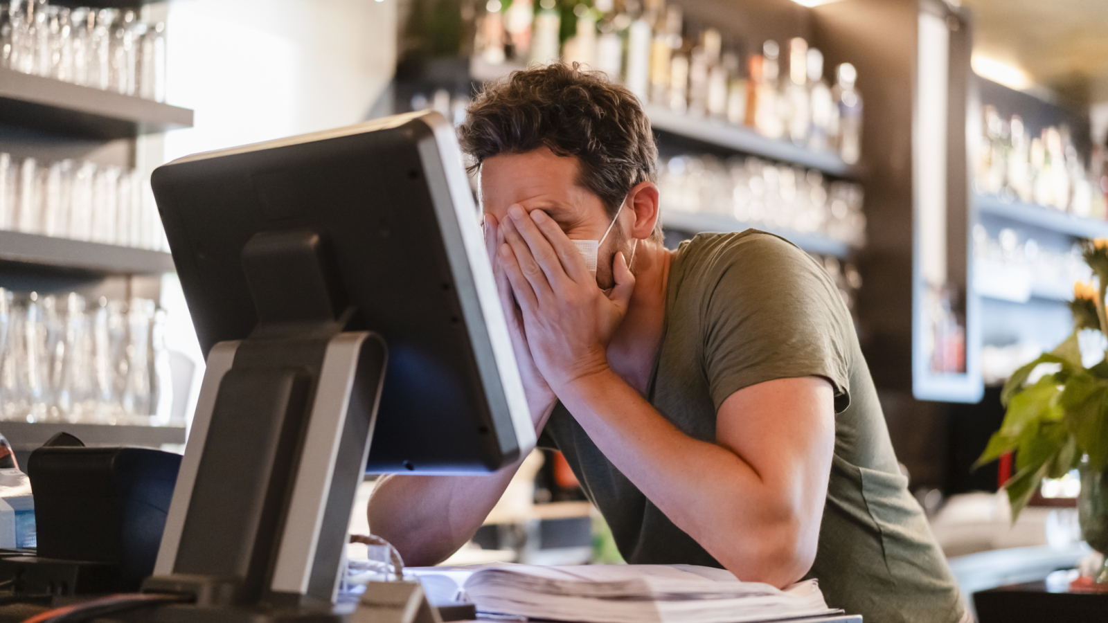 Restaurant manager with hands in face during corona crisis