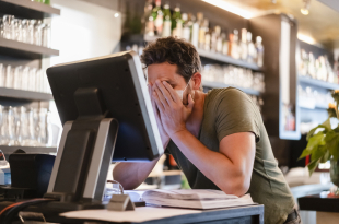 Restaurant manager with hands in face during corona crisis