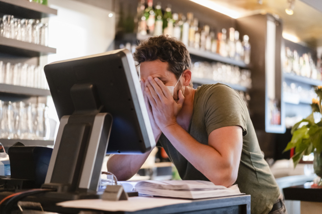 Restaurant manager with hands in face during corona crisis