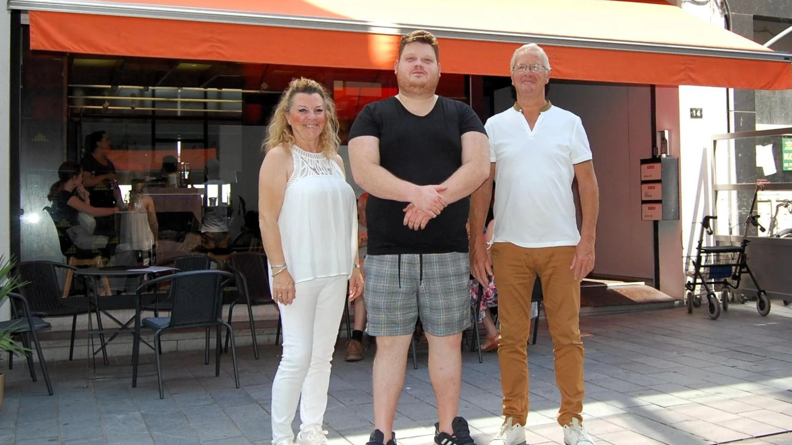 Nickola Huybens wordt geflankeerd door mama Dominique en papa Regi voor het terras van brasserie Balou