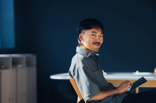 Young Professional Holding a Digital Tablet Looking Confident in a Modern Office Setting