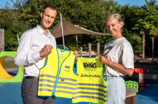 Karel Docker overhandigt de hesjes aan directrice Marlies Storms van De Knipoog in Olen