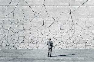 Businessman standing in front of breaking wall