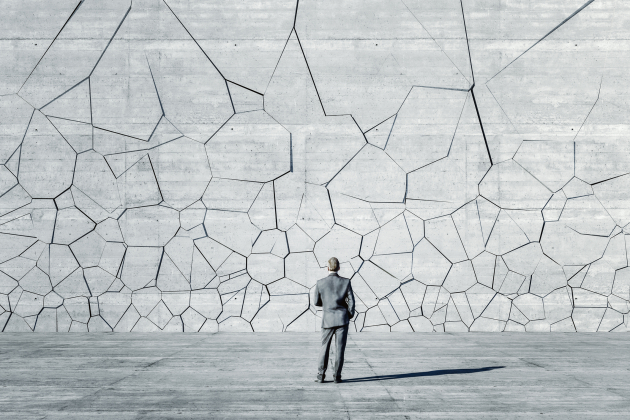 Businessman standing in front of breaking wall