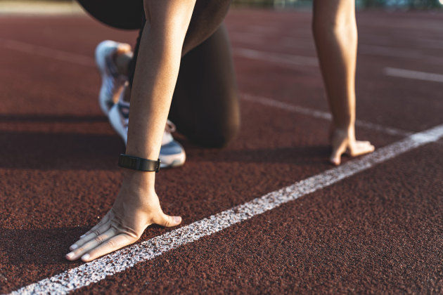 Female athlete on the starting line of a stadium track