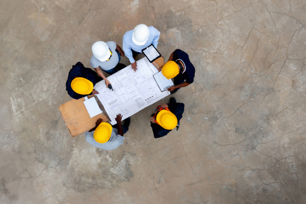Group of construction workers in a meeting looking at a blueprint