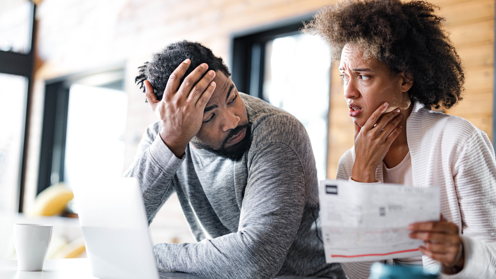 Young black couple having problems with online banking at home.