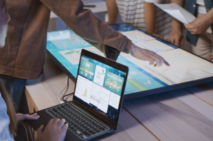 Asian business people team brainstorm meeting in sustainable office at night, using computer monitor. Discuss ESG (environmental social corporate governance) project planning. Responsible organization