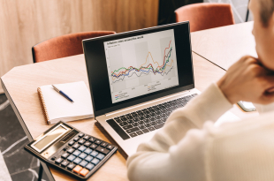 Businessman work in cafe with laptop. Inflation chart on the screen.