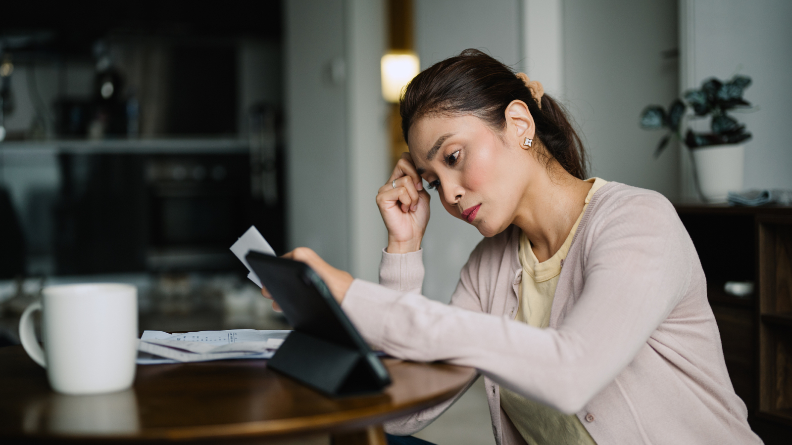 Asian Malay female planning family finances at home.