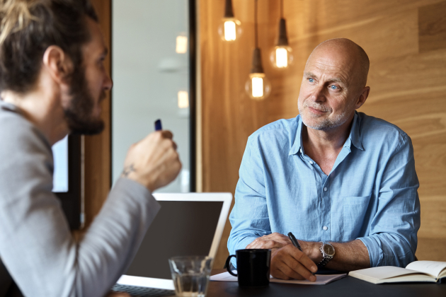 Businessman listening to colleague at table