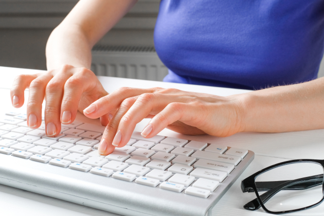 Female hands type text on the keyboard of a computer or laptop. A woman, an office worker at her desk. The concept of business, freelancing, work at home. IT support, network security, online social support. Distance learning online.