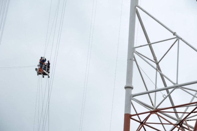 Waaghalzen van CRI klimmen naar boven om een installatie van TotalEnergies te onderhouden.