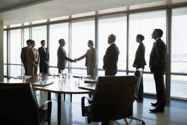 Business people shaking hands in conference room