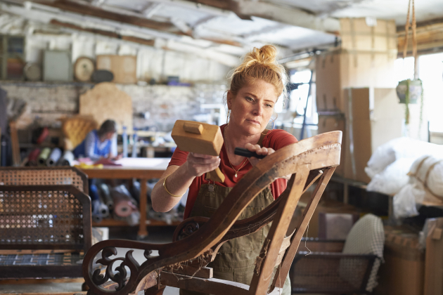 An upholsterer working on a chair