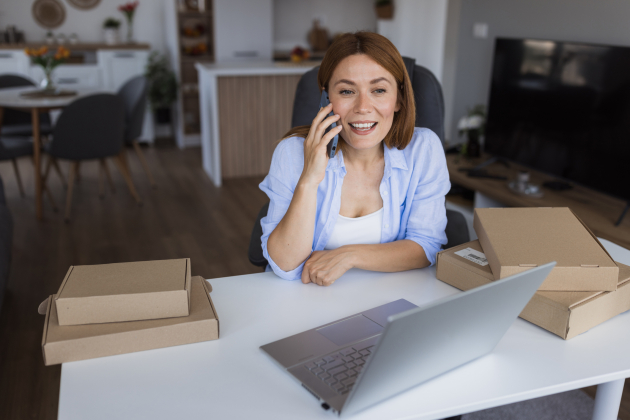Woman managing her online business from home office talking on phone