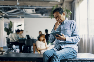 Mature man looks at tablet with a worried expression