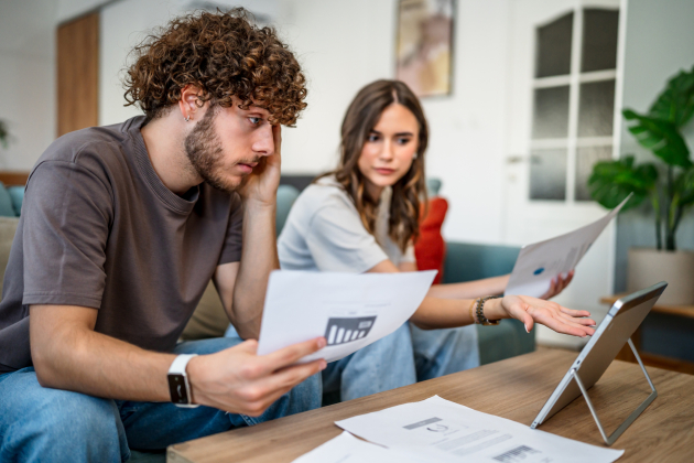 Young couple stressed about finance calculating budget at home