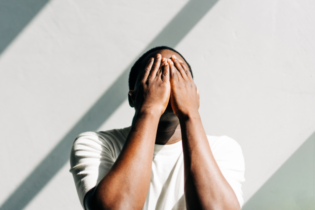 African American man tired and stressed, covered his face with his hands. Mental health, prevention of burnout and depression.