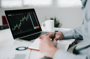 Young businessman using laptop for analyzing data stock market.