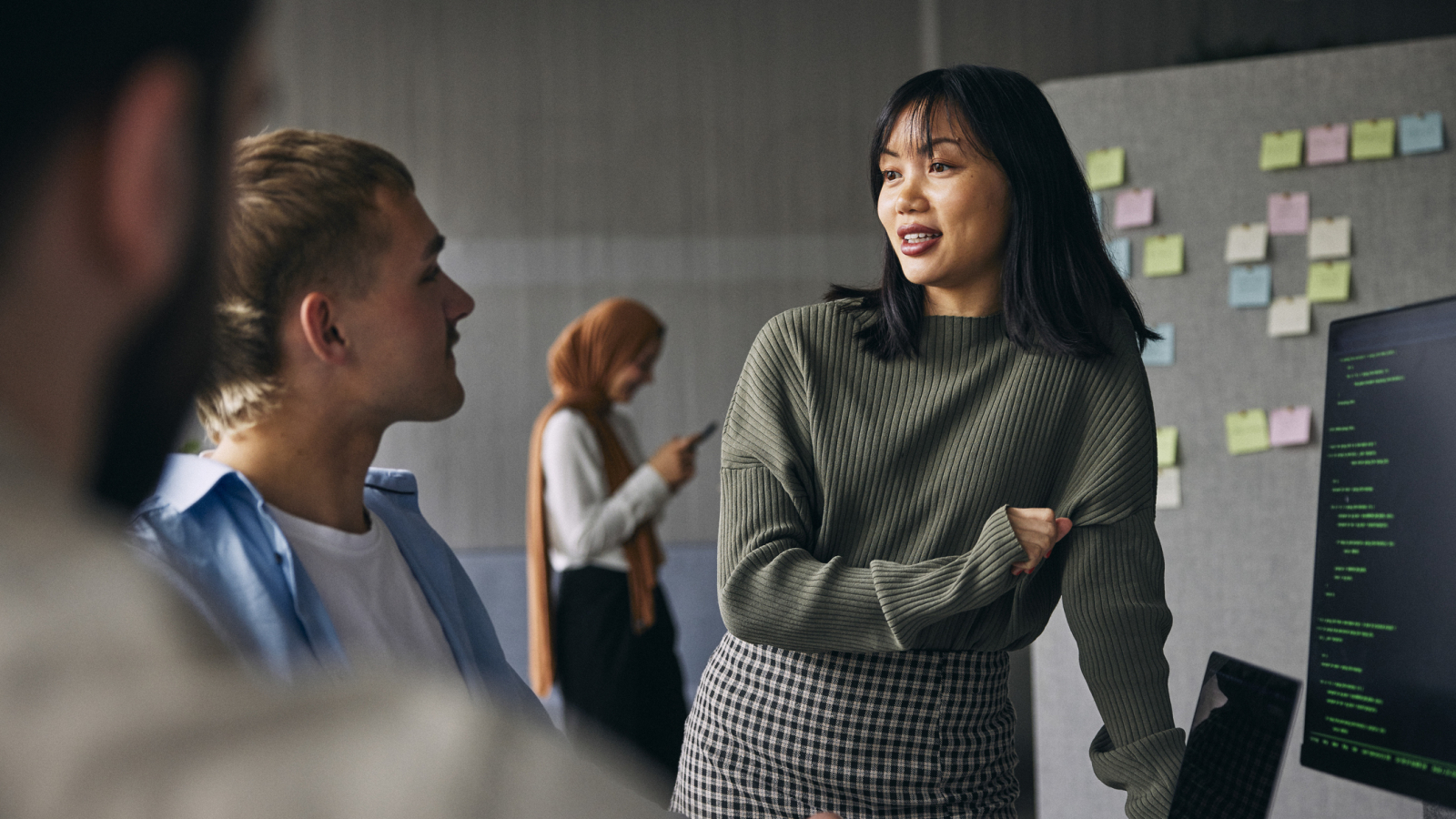 Businesswoman discussing ideas with colleagues in meeting at tech startup office