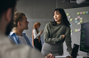 Businesswoman discussing ideas with colleagues in meeting at tech startup office