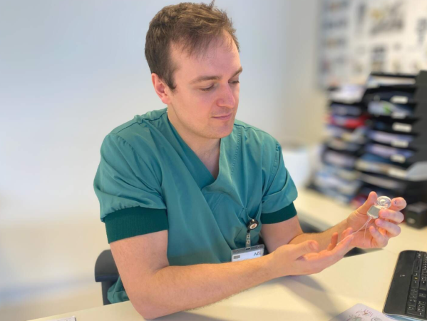 Dokter Tillo Mertens houdt een cochleair implantaat in zijn hand