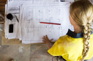 A female construction worker looks at site plans