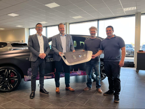 Tom Troch en Stijn Meeusen van BMW met rechts leerkrachten Stefan Degueldre en Benny Koyen van Vito Hoogstraten bij de symbolische sleuteloverdracht.