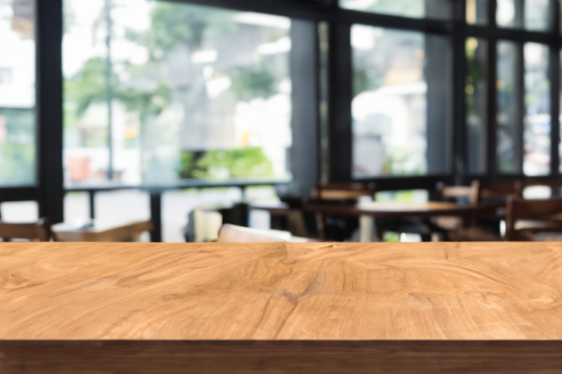 Wooden board empty table in front of blurred background.  Brown wood over blur in coffee shop. Can be used for display or montage your products. Mock up for display of product.