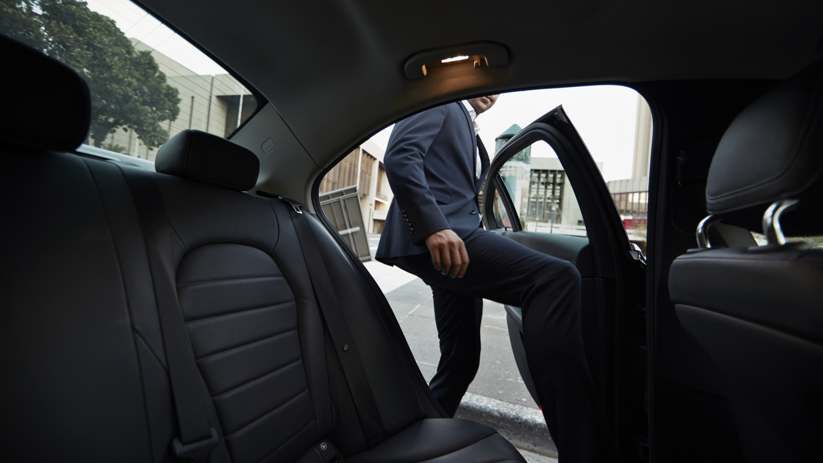 Businessman getting into backseat of exclusive cab