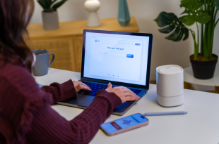 Woman using AI chatbot on laptop in home office