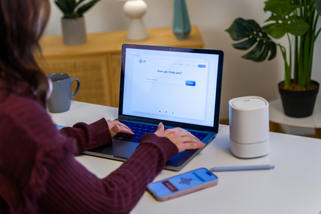 Woman using AI chatbot on laptop in home office