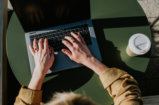 Close-up of hands typing on a laptop computer