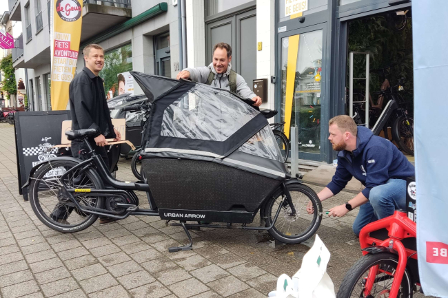 Nick Verrydt (links) en Joppe Van Den Broeck (rechts) van Fietsen De Geus pompen de banden van een passerende bakfietser op