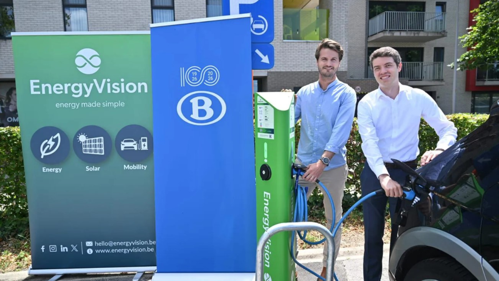 Sander Wille van EnergyVision (links) en Alexandre Viviers van NMBS pluggen een elektrische auto aan een van de 24 laadpunten waarmee de parking van het station in Herentals is uitgerust.