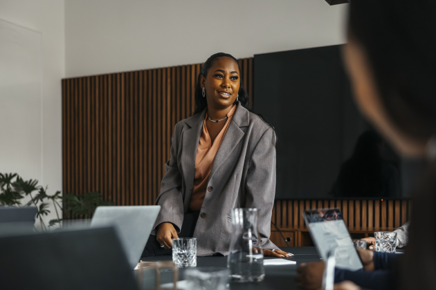Low angle view of businesswoman communicating with colleagues in office meeting at board room