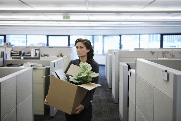 Young businesswoman carrying cardboard box in office, portrait