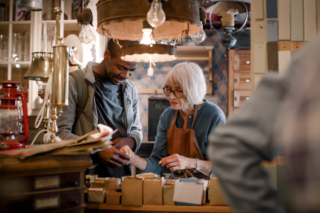 Senior female sales clerk assisting male customer with nails at hardware store