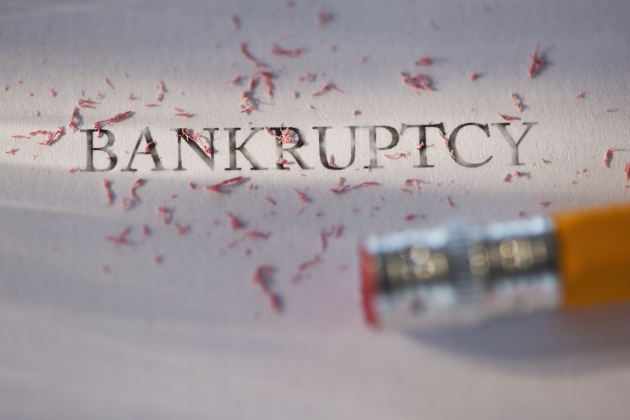 Studio shot of pencil erasing the word bankruptcy from piece of paper