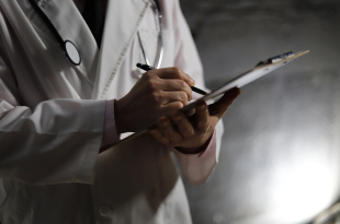 Close up of doctor writing on chart