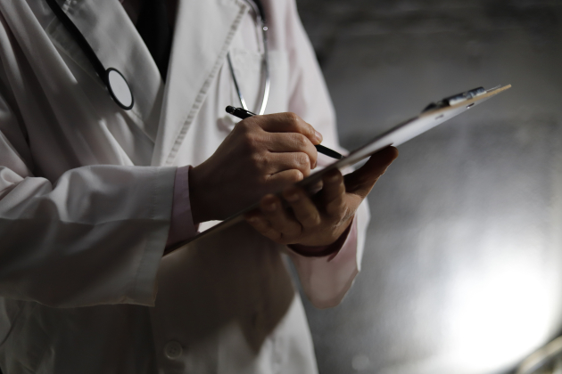 Close up of doctor writing on chart