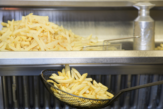 Close up of French fries cooking.