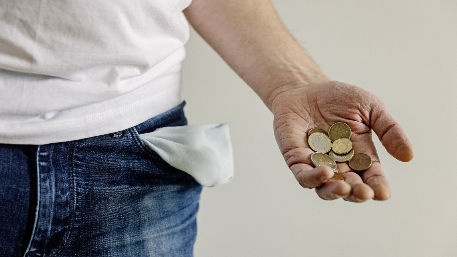 Man holding coins in palm of hand