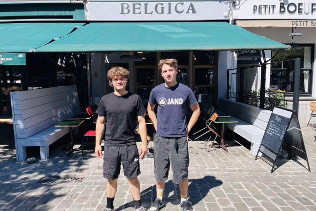 Felix en Adam poseren voor de gevel van café Belgica