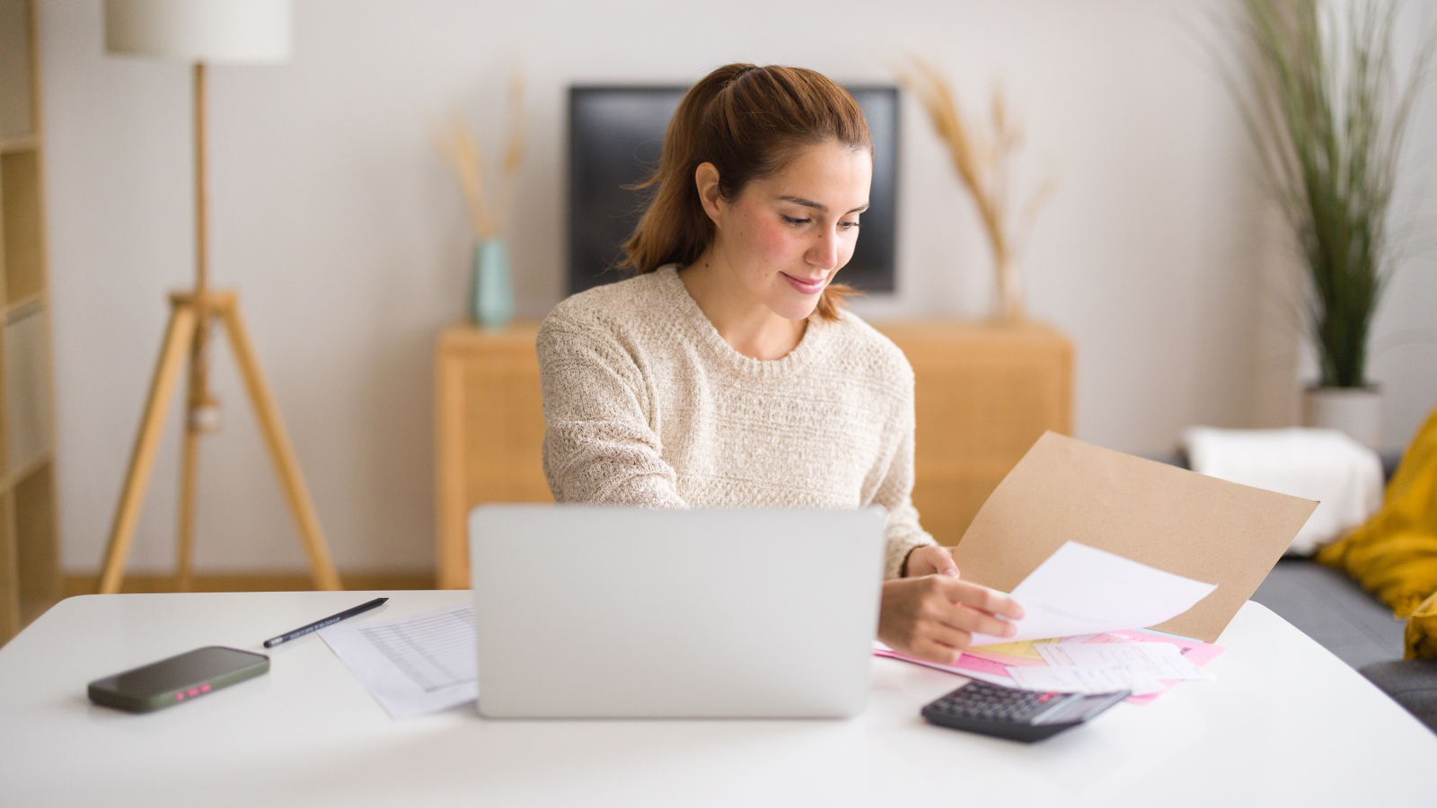 Young businesswoman working from home managing her finances and consulting documents