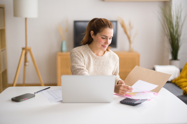 Young businesswoman working from home managing her finances and consulting documents