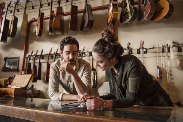 Young couple working behind counter in music store