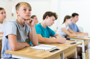 Teenager,Students,Sitting,At,Desks,And,Listening.,Boy,Sitting,In